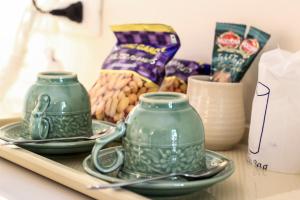 two green jars sitting on a table with snacks at 3B Boutique Hotel in Chiang Mai