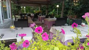 una mesa con flores rosas frente a un restaurante en Park Hotel, en Castel San Pietro Terme