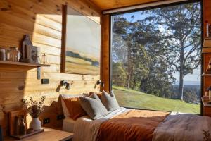 a bedroom with a large window in a log cabin at Heyscape Denmark in Denmark