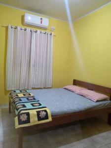 a bedroom with a bed in a room with a window at Casa da Santa in Coruripe