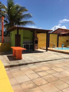 a orange table sitting on a patio next to a pool at Casa da Santa in Coruripe