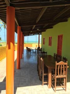 a dining room with a table and chairs and the ocean at Casa da Santa in Coruripe
