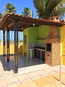 a patio with an outdoor kitchen with a brick oven at Casa da Santa in Coruripe +5 photos