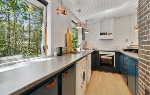 a kitchen with blue cabinets and a large window at 3 Bedroom Gorgeous Home In Nexø in Neksø