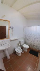 a bathroom with two sinks and a toilet and a mirror at El Faro Casas de Mar in Camarones
