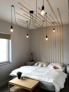 a bedroom with a large white bed and lights at Wonderful house on water with 5 bedrooms and bathrooms in Stavoren