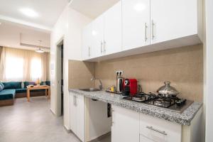 a kitchen with white cabinets and a stove top oven at Central Agadir, Modern and Convenient in Agadir