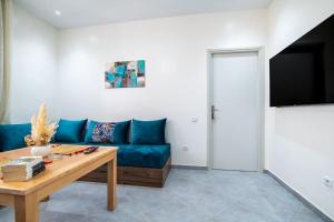 a living room with a blue couch and a table at Central Agadir, Modern and Convenient in Agadir