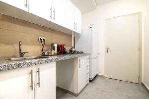 a kitchen with white cabinets and a sink and a refrigerator at Central Agadir, Modern and Convenient in Agadir +11 photos