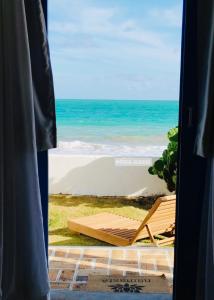 a view of the beach from a window at Casa Prema - Experiência vegana e terapêutica à beira-mar in Maceió