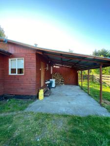 a building with a patio next to a house at Cabañas Doña Norma in Puyehue