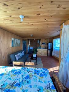 a bedroom with a bed and a living room at Cabañas Doña Norma in Puyehue
