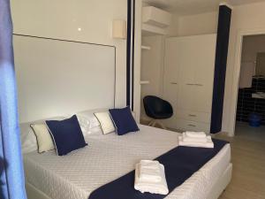 a bedroom with a bed with blue and white pillows at Cala Rosa Club Hotel in Stintino