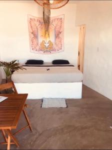 a bed in a room with a picture on the wall at Casa Prema - Experiência vegana e terapêutica à beira-mar in Maceió