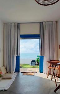 a living room with a view of the ocean at Casa Prema - Experiência vegana e terapêutica à beira-mar in Maceió