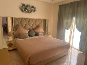 a bedroom with a large bed with a large window at superbe appartement en résidence balnéaire in Bouznika +17 photos