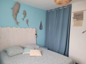 a bedroom with a bed with a blue wall at Maison avec grange, jeux et enquête in Petit Bailly