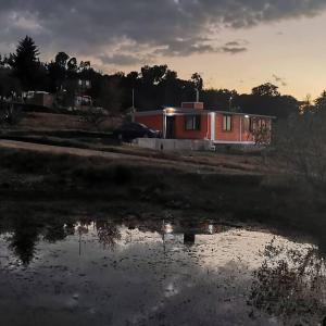 a house with a reflection in a puddle of water at Casa de descanso in Yanthé