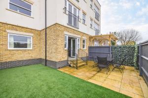 a patio with a table and chairs in front of a building at Modern 2 Bed Oasis - Private parking & Garden in Windsor