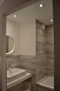 a bathroom with a sink and a tub and a mirror at Chalet Le Quartz in Val Thorens +30 photos