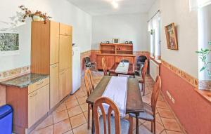 a dining room with tables and chairs and a kitchen at Ferienwohnung Kuchelmiß in Kuchelmiß