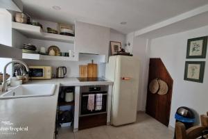 a kitchen with a white refrigerator and a sink at La Casita Rustica in Almuñécar