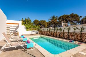 a swimming pool with chairs next to a fence at Villa Ca Na Margarita by Villa Plus in Cala Blanca