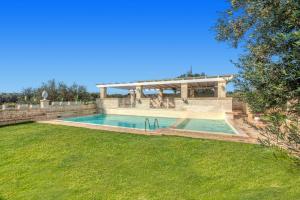 a swimming pool in a yard with a house at Villa Amico by Villa Plus in Grottaglie