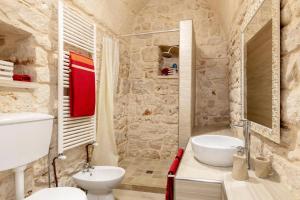 a stone bathroom with a sink and a toilet at Villa Amico by Villa Plus in Grottaglie