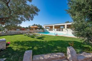 a backyard with a swimming pool and a house at Villa Amico by Villa Plus in Grottaglie