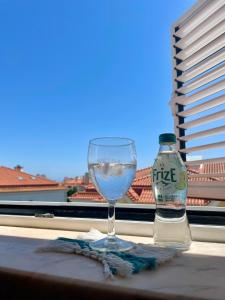 a wine glass and a bottle of water on a table at Cozy Carcavelos Beach-NOVA SBE in Carcavelos +14 photos