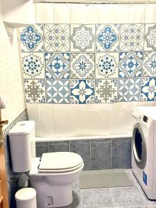 a bathroom with a toilet and a washing machine at Cozy Carcavelos Beach-NOVA SBE in Carcavelos