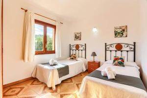 a bedroom with two beds and a window at Villa Andreu by Villa Plus in El Port +17 photos