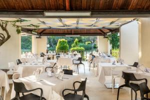 ein Bankettsaal mit weißen Tischen und Stühlen in der Unterkunft VOI Floriana Resort in Simeri Mare