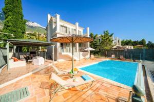a home with a swimming pool and a house at Villa Andrea by Villa Plus in Lourdhata