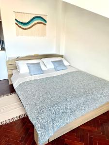 a bedroom with a large bed with blue pillows at Cozy Carcavelos Beach-NOVA SBE in Carcavelos