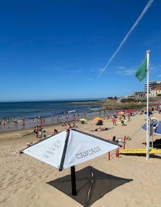 a sign on a beach with a crowd of people at Cozy Carcavelos Beach-NOVA SBE in Carcavelos
