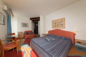 a bedroom with a bed and a table and chairs at Hotel Catullo in Sirmione