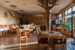 a restaurant with wooden tables and chairs and windows at Hotel Księcia Józefa in Poznań
