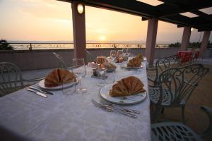 a table with plates of food on top of a balcony at Hotel Catullo in Sirmione +42 photos