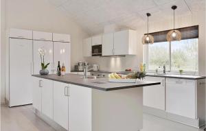 a white kitchen with white cabinets and a sink at Beautiful Home In Idestrup With Sauna in Marielyst +25 photos
