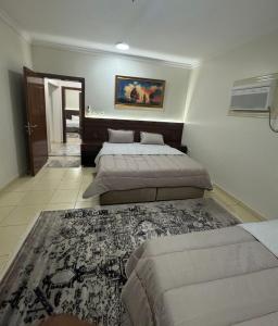Un dormitorio con dos camas y una alfombra. en شقة العقيق الأولى, en Medina
