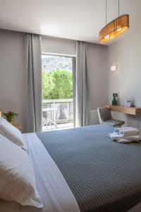 Un dormitorio con una cama grande y una ventana en Anemos Rooms & Apartments, en Nauplia