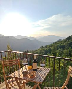 a table with two glasses of wine on a balcony at L' Orso Felice - alloggio turistico a Campo Felice in Collimento