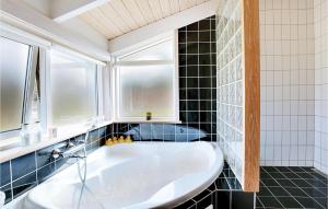 a bathroom with a tub and a window at Three-Bedroom Holiday Home In Sjallands Odde in Tjørneholm