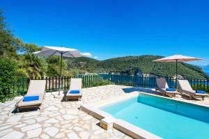 a swimming pool with lounge chairs and umbrellas at Villa Votsalo Desimi by Villa Plus in Katokhórion