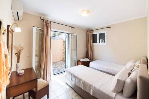 a hotel room with two beds and a balcony at Villa Votsalo Desimi by Villa Plus in Katokhórion +11 photos