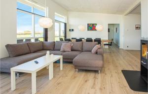 a living room with a couch and a table at Four-Bedroom Holiday Home Haderslev With A Room Hot Tub 02 in Knud