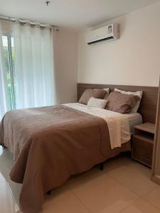 a bedroom with a large bed and a window at Brisas do Lago em Brasília in Brasilia
