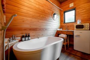 a white tub in a bathroom with wooden walls at Kita Karuizawa Morino Takibi Dogs OK! in Tsumagoi +61 photos